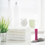 Foreo Espada Blue Light Acne Treatment  on  bathroom counter next to white towels and plant