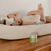 earth mama organic diaper balm on table in front of baby laying down on back